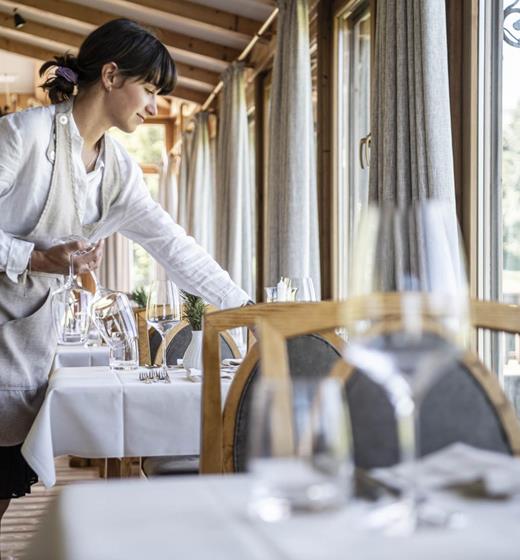 A waitress is setting a table in the dining room