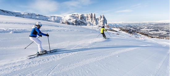 Due persone che fanno sci sull'Alpe di Siusi