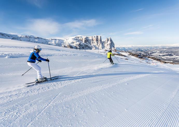 Due persone che fanno sci sull'Alpe di Siusi