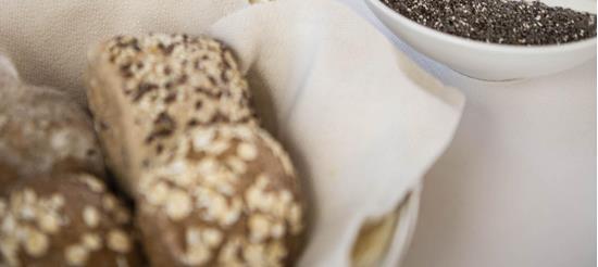 Frühstück mit Joghurt, Chiasamen, Beeren, Brötchen, Omelett, Tee und Wasser