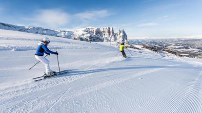 Due persone che fanno sci sull'Alpe di Siusi