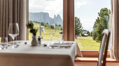 A table in the dining room with a view on the Seiser Alm
