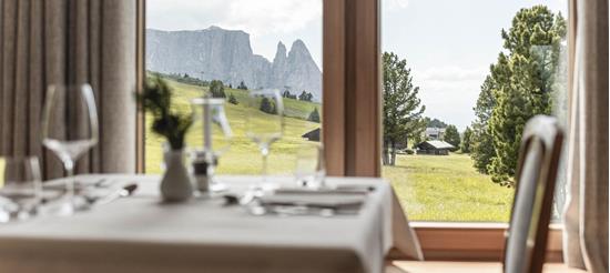 A table in the dining room with a view on the Seiser Alm