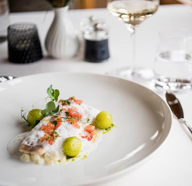 Tender fish with foam, diced tomatoes and vegetable spheres