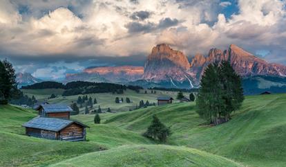 Alpenglühen in den Dolomiten – sanfte Hügel, urige Hütten und dramatisches Abendlicht