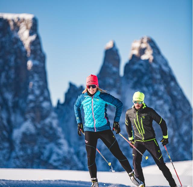 Two people are cross-country skiing