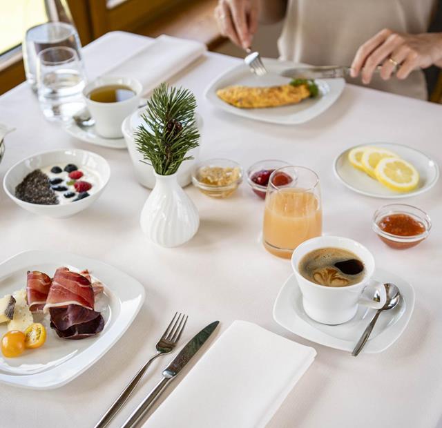 Hearty breakfast with cold cuts, cheese, omelette, yogurt, jam, coffee and juice