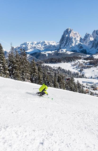 Zwei Skifahrer fahren eine schneebedeckte Piste hinunter